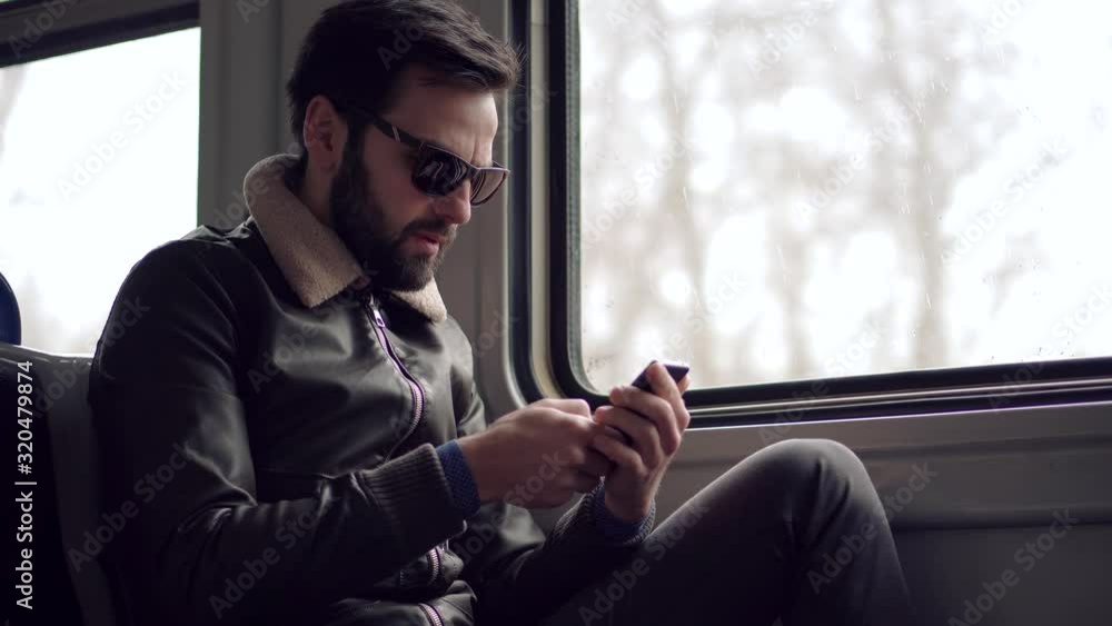 Man Using Mobile Phone On Train.Handsome Businessman Chatting On Mobile Phone With Friend Sending Message On Social Network.Man Texting On Smartphone In Tram.Guy Holding Cellphone In Public Transport. Man Using Mobile Phone On Train.Handsome Businessman Chatting On Mobile Phone With Friend Sending Message On Social Network.Man Texting On Smartphone In Tram.Guy Holding Cellphone In Public Transport.
