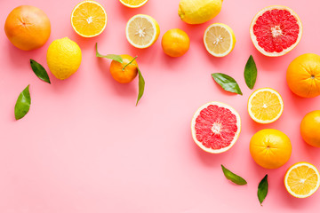 Fresh citrus frame. Oranges, tangerines, grapefruits, leaves on pink background top-down copy space