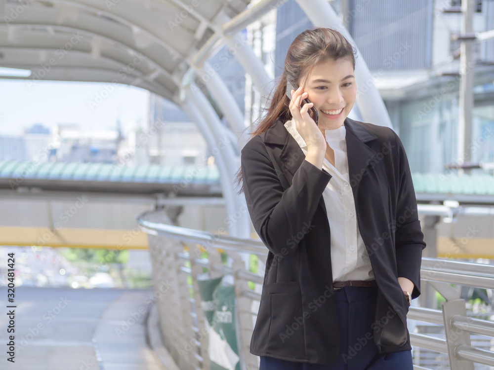 Asian business woman holding coffee paper cup enjoy calling smartphone at outdoor office. Asian business woman holding coffee paper cup enjoy calling smartphone at outdoor office.
