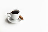 White cup of coffee on a white saucer cinnamon sticks with place for text on a white background top view