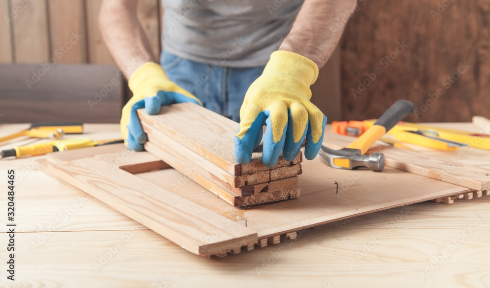 Carpenter holding wooden planks. Woodworking industry Carpenter holding wooden planks. Woodworking industry