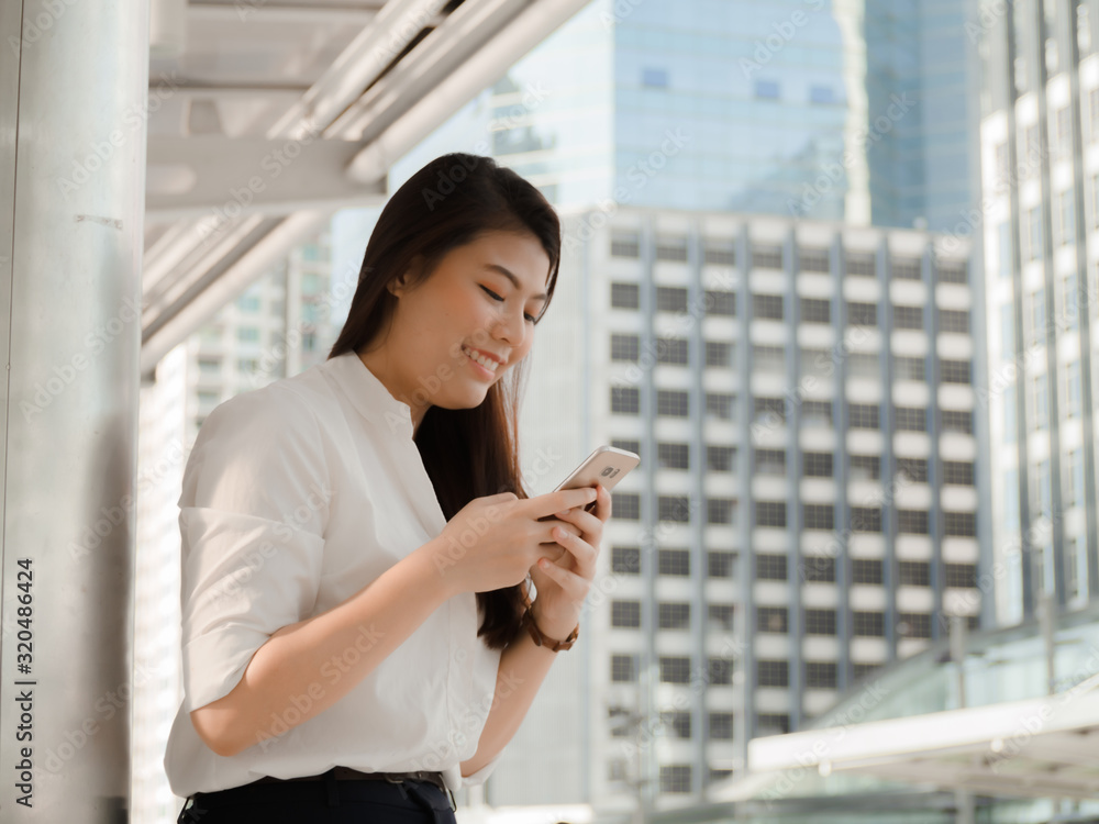Professional Asian business woman smiling use smartphone chat working to outdoor city. Professional Asian business woman smiling use smartphone chat working to outdoor city.