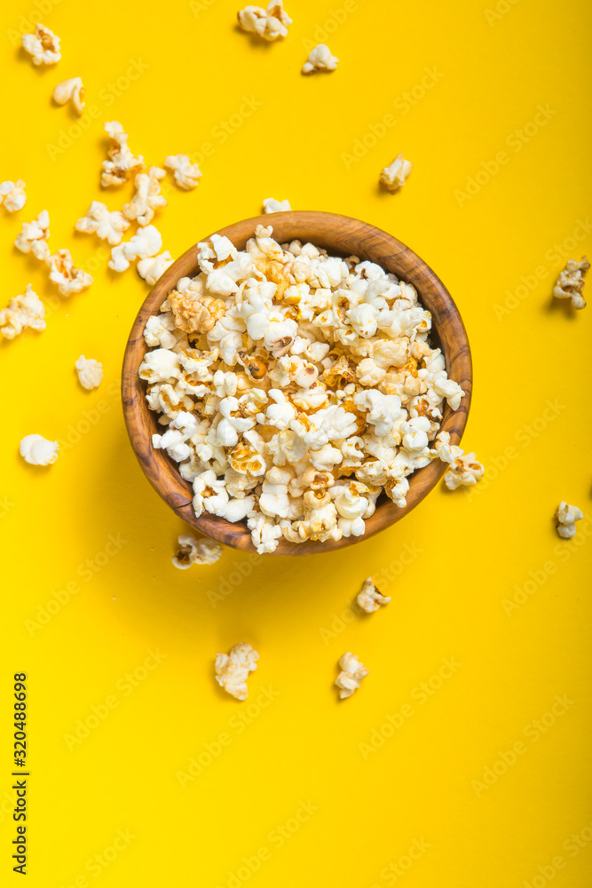Popcorn viewed from above on yellow background. Flat lay bowl. Top view Popcorn viewed from above on yellow background. Flat lay bowl. Top view