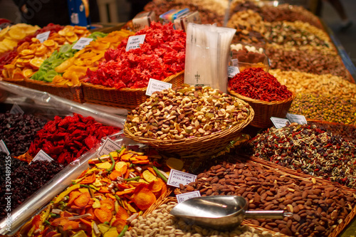 Delicious vibrant colored dried fruits and nuts variety in basktes on a food market stall: pistachios, almond, , close up © natalyon