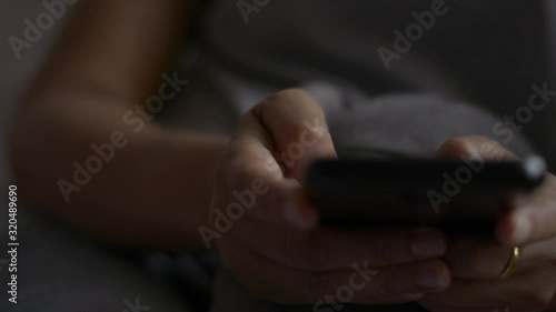 Close up woman hands texting message on mobile smart phone for communication and chatting on social online in the bed room.