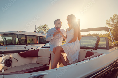 Couple in a river boat or yacht toasting with sparkling wine © Kzenon