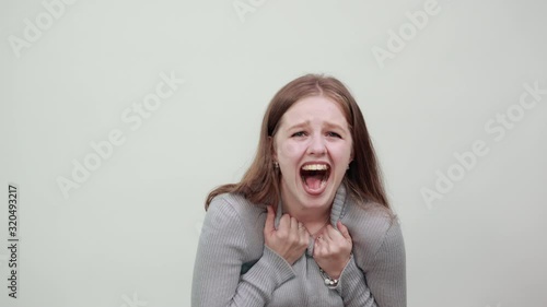 Woman with wide open mouth grey clothes background aggression scream