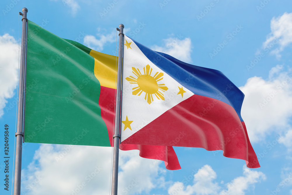 Philippines and Benin flags waving in the wind against white cloudy blue sky together. Diplomacy concept, international relations. Philippines and Benin flags waving in the wind against white cloudy blue sky together. Diplomacy concept, international relations.