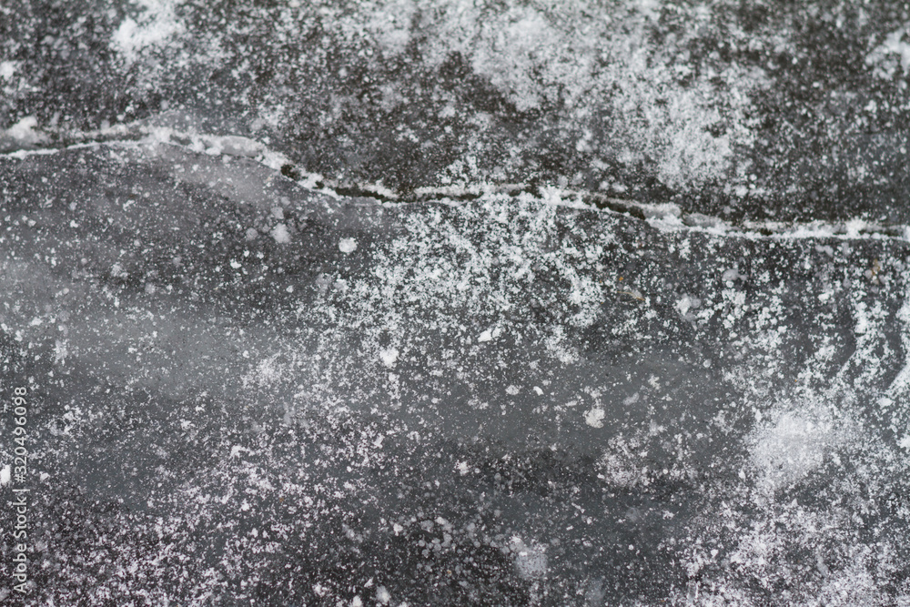 Texutured ise surface of frozen lake. Close up. Scattered white snow around. Winter background. Texutured ise surface of frozen lake. Close up. Scattered white snow around. Winter background.