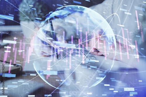 Financial forex graph displayed on hands taking notes background. Concept of research. Double exposure