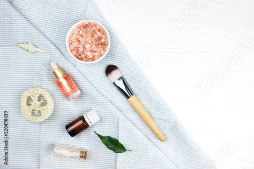 Homemade spa cosmetic set with salt and oil on white wooden background. Copy space. Flat lay style.