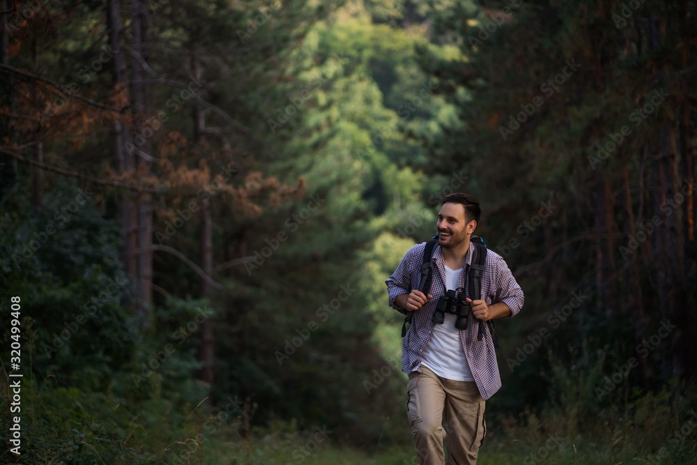 Happy adult man is hiking in forest. Happy adult man is hiking in forest.
