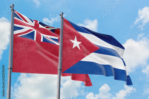 Cuba and Bermuda flags waving in the wind against white cloudy blue sky together. Diplomacy concept, international relations. photo