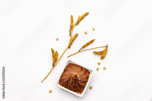 Light brown miso paste isolated on white background. Traditional Japanese seasoning, dry soya beans pods