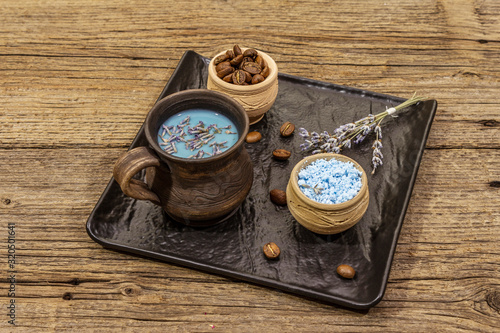 Trendy colored latte. Lavender and powdered aromatic sugar, coffee beans. Wooden boards background