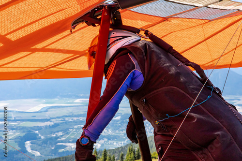 Close-up of Hang Glider preparing to take off in the Kootenay valley mountains, Creston, British Columbia, Canada. View from behind