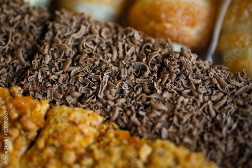 Shallow depth of field (selective focus) and macro image with chocolate flakes on sweets.