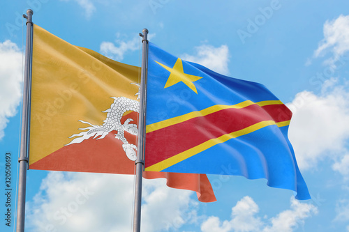 Congo and Bhutan flags waving in the wind against white cloudy blue sky together. Diplomacy concept, international relations.