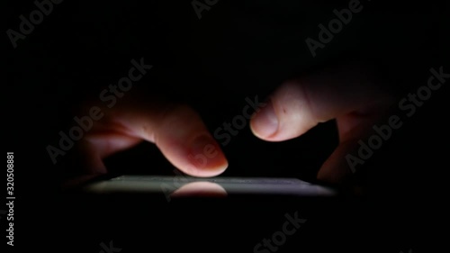 Man Hands Typing text on smartphone at night.