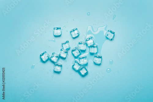 Ice cubes with water on a blue background. Ice concept for drinks. Banner. Flat lay  top view