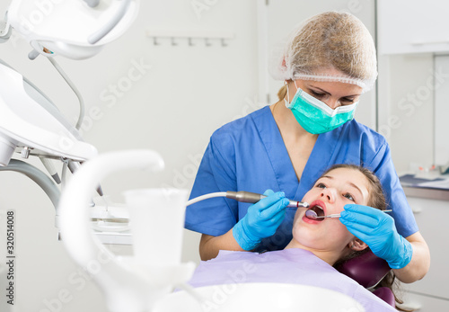 Female dentist treating girl