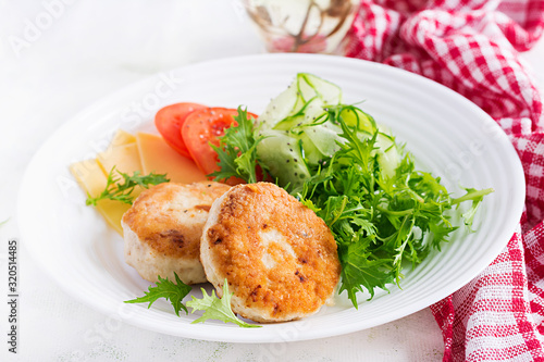 Fototapeta Naklejka Na Ścianę i Meble -  Ketogenic lunch. Chicken burger with tomato, cucumber, cheese and arugula salad without bun. Chicken patties. Healthy food. Keto/paleo diet.