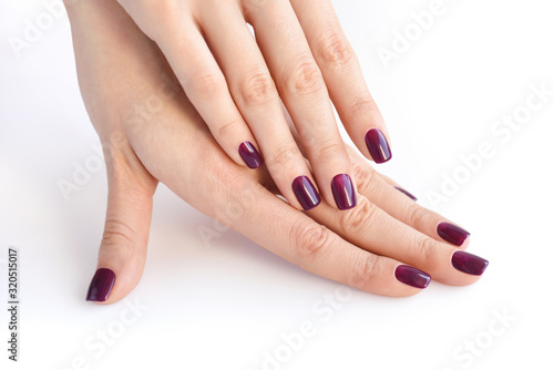 Closeup of hands of a young woman with dark manicure on nails