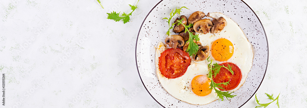 Ketogenic food. Fried egg, mushrooms and sliced tomatoes. Keto, paleo breakfast. Top view, overhead, banner Ketogenic food. Fried egg, mushrooms and sliced tomatoes. Keto, paleo breakfast. Top view, overhead, banner