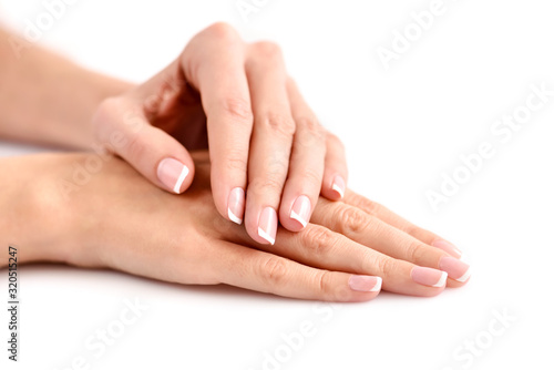 Beautiful woman hands with french manicure on a white background