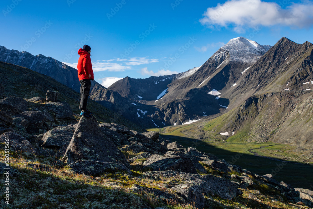Tourist on the background of the mountain landscape of the polar Urals of Russia. Inaccessible mountains of the national park Tourist on the background of the mountain landscape of the polar Urals of Russia. Inaccessible mountains of the national park