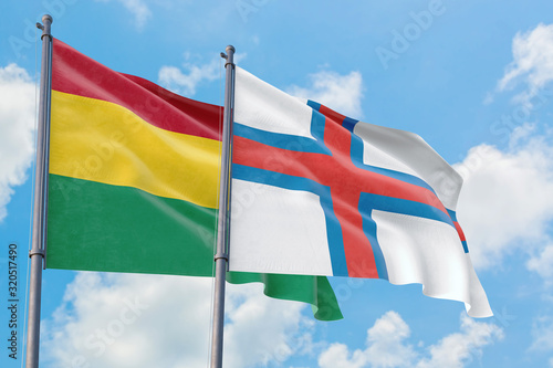 Faroe Islands and Bolivia flags waving in the wind against white cloudy blue sky together. Diplomacy concept, international relations.