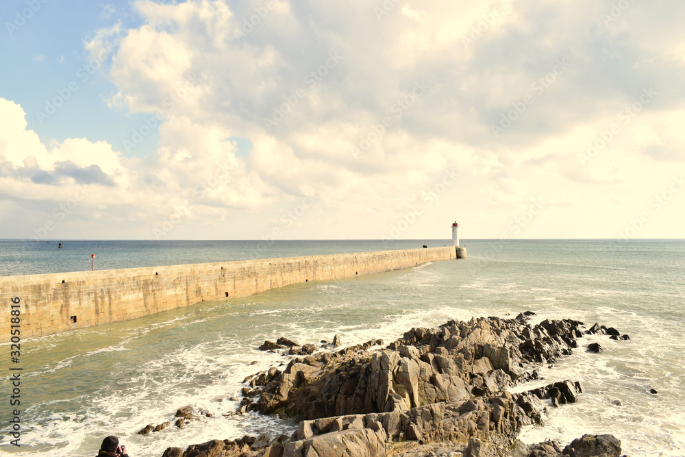 Audierne ville du Finistère en Bretagne sa baie son phare sa jetée le pont et les vagues qui se jettent sur les rochers en projetant de l'écume à marée haute