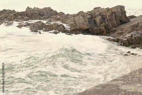 Audierne ville du Finistère en Bretagne sa baie son phare sa jetée le pont et les vagues qui se jettent sur les rochers en projetant de l'écume à marée haute