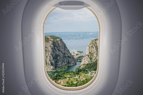 View from airplane window on Omis city in Croatia. Travel and vacation concept.