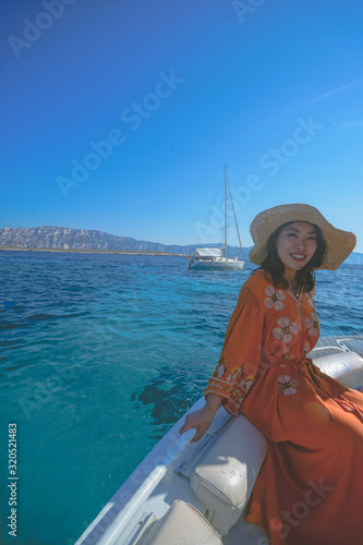 Marseille, France - August 13th, 2019:A young woman is enjoying sunshine and beautiful view in Calanques de Morgiou, Marseilles, Provence, South of France.  She looks very cheerful and happy.