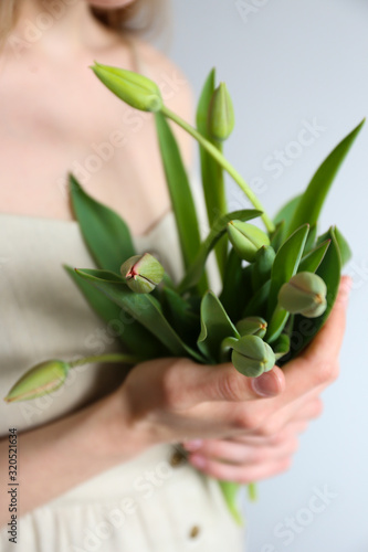 Conceptual image of a woman holding spring flowers as present for international women s day. Close up  copy space  background.
