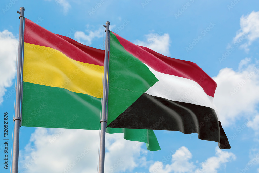 Sudan and Bolivia flags waving in the wind against white cloudy blue sky together. Diplomacy concept, international relations. Sudan and Bolivia flags waving in the wind against white cloudy blue sky together. Diplomacy concept, international relations.