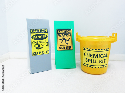 The Chemical Spill kit in yellow bucket and warning danger caution hazard tag sign or symbol for emergency response situation when the chemical spill out, safety first in laboratory workplace concept.