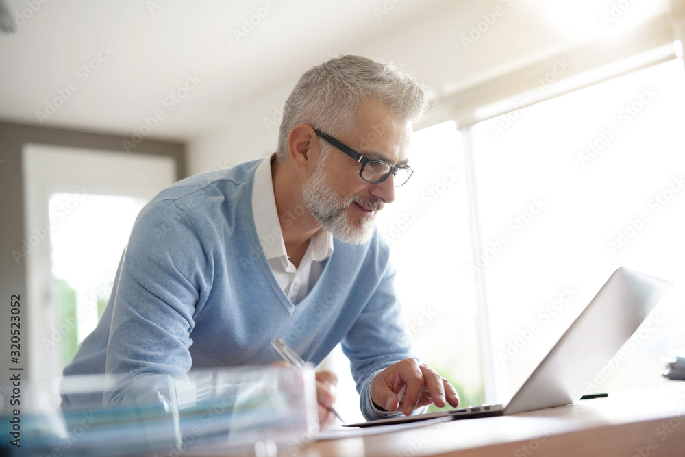 Man in office working on laptop computer Man in office working on laptop computer