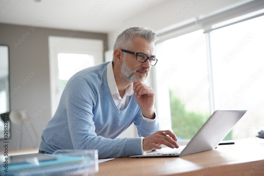 Man in office working on laptop computer Man in office working on laptop computer