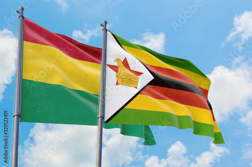 Zimbabwe and Bolivia flags waving in the wind against white cloudy blue sky together. Diplomacy concept  international relations.