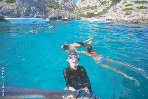 Marseille, France - August 13th, 2019:People are swimming and diving in Calanques de Morgiou, Marseilles, Provence, South of France.  Everyone looks very cheerful and happy. photo