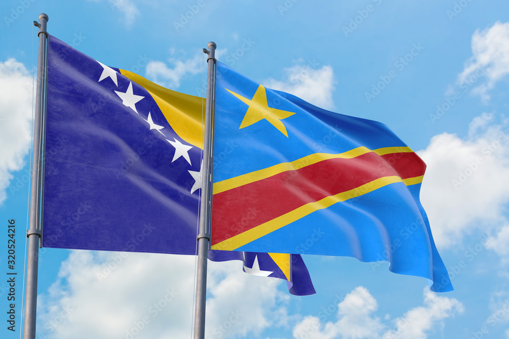 Congo and Bosnia Herzegovina flags waving in the wind against white cloudy blue sky together. Diplomacy concept, international relations.
