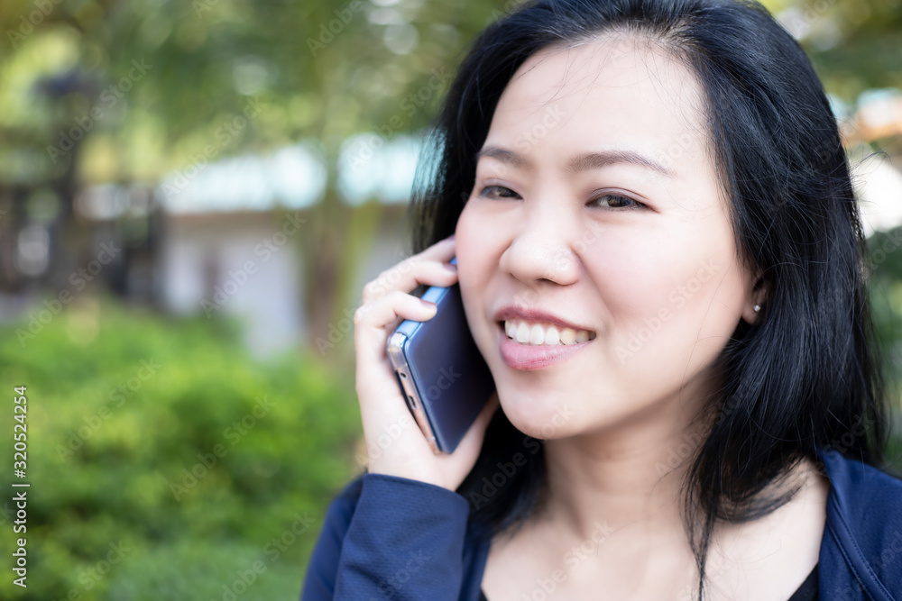 Asian woman talking on smart phone at park. Communication concept. Extrovert characteristic. chit chat with friend. Asian woman talking on smart phone at park. Communication concept. Extrovert characteristic. chit chat with friend.