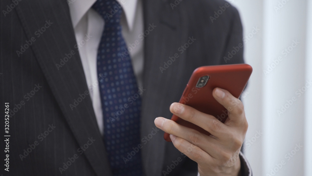 スマートフォンを操作しているビジネスマン スマートフォンを操作しているビジネスマン