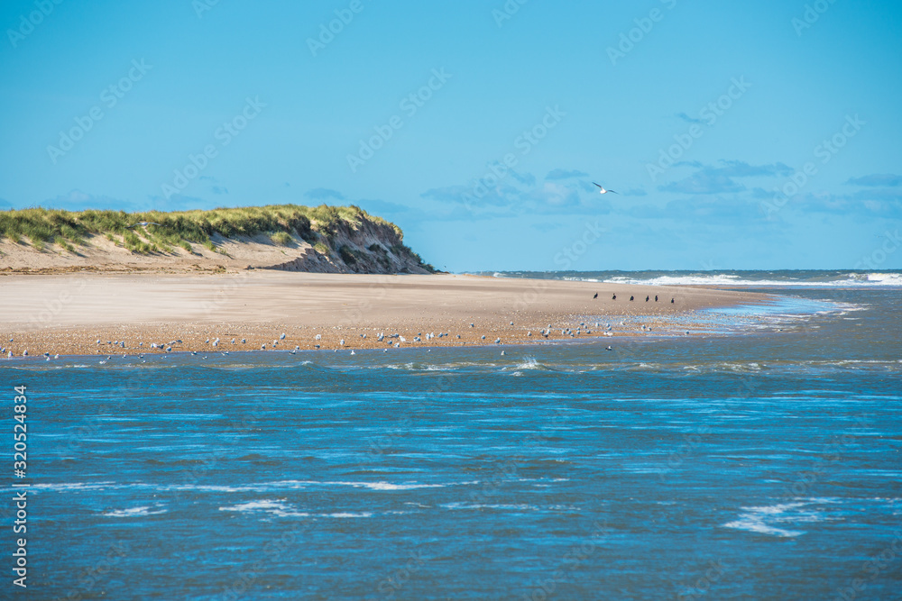 Scolt Head Island National Nature Reserve seen from Holkham beach across the narrow Burn river estuary. North Norfolk coast. East Anglia. England. UK. Scolt Head Island National Nature Reserve seen from Holkham beach across the narrow Burn river estuary. North Norfolk coast. East Anglia. England. UK.