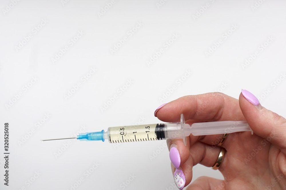 medical syringe in the woman's hand for injection on a white background. medical syringe in the woman's hand for injection on a white background.