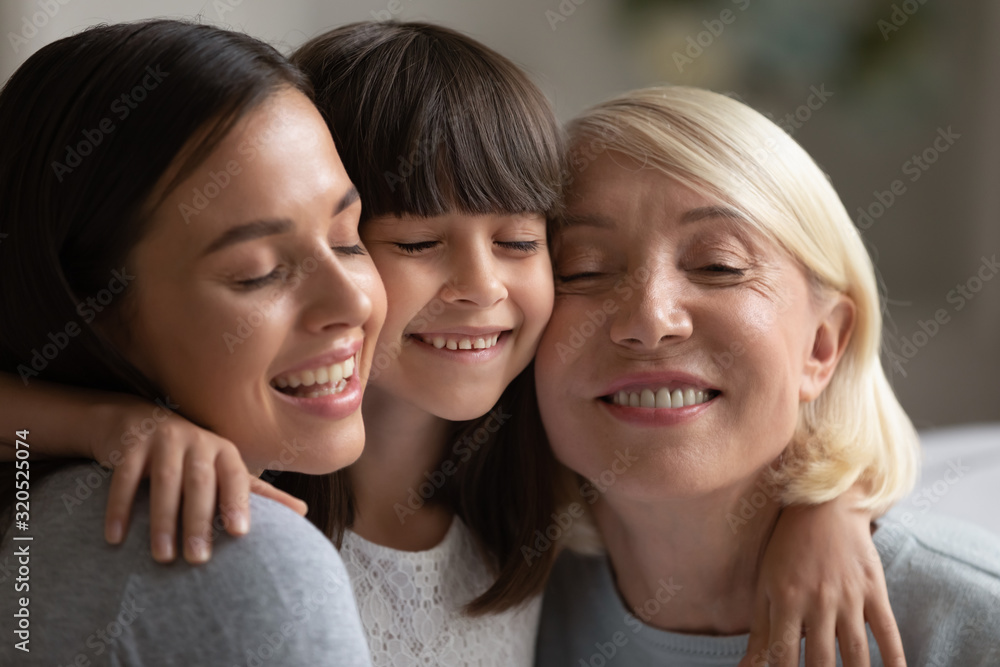 Smiling three generations of women hug and cuddle Smiling three generations of women hug and cuddle