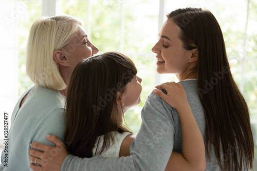 Happy three generations of women hug showing unity