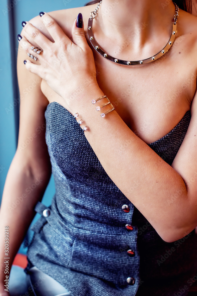 Hands and body of a girl decorated with different decorative jewelry. Bracelet on a hand close-up.